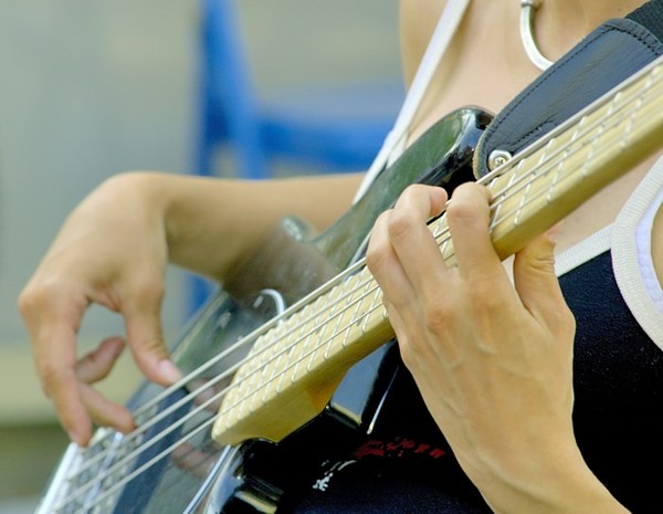 Fingers of a bass guitar player at a street festival in Toronto.